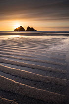 RF - Holywell Bay at low tide, ripples and reflections at sunset, looking towards Carter's Rocks.   Cornwall, UK. March.   (This image may be licensed either as rights managed or royalty free)