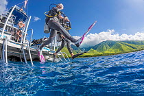 Divers  stepping off dive boat into ocean, near Ukumehame, Maui, Hawaii. Pacific Ocean. Model released
