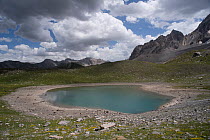 Alpine lake at an altitude of 2400 m, drying up during heatwave in summer, Lac des Rouites, Queyras, The Alps, France. 4th July, 2022.