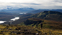 Tourists hiking with the Cuillin mountains and Loch Leathan in the background, Trotternish peninsular, Isle of skye, Scotland, UK.