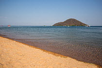 Sandy beach in front of Thumbi View Lodge with view of lake.  Thumbi West Island, Lake Malawi, Malawi.