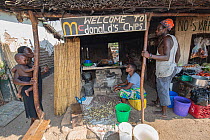 Peop[le at local snack-restaurant that claims to be the McDonalds of area. Lake Malawi, Malawi.