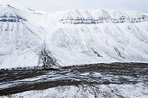 River flowing through snow-covered Bolterdalen valley in early autumn. Svalbard, Norway. September, 2019.