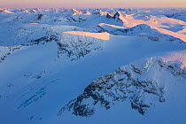 Snow-covered mountain landscape at sunset with  Mount Veslfjelltinden in the foreground, Jotunheimen National Park, Norway. April, 2019.