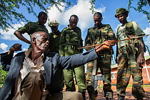Ex-poacher holding poison arrow, explaining to Kenya Wildlife Service rangers and David Sheldrick Wildlife Trust scouts about the use of poison arrows to kill elephants, Tsavo East National Park, Keny...