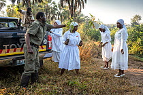 Gorongosa head warden planting trees with his family along the river edge to help prevent erosion. All the women in the family wear white at all times - part of their culture as a Christian sect, Goro...