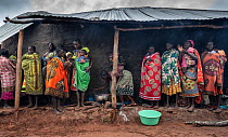 Women and children gathering together under a shelter to eat high nutrition porridge. The porridge is fed to the children to improve their nutritional intake and is specially formulated to provide key...