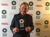 Photographer David Maitland, holding his award at the British Photography Awards ceremony 2022.