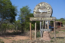 Wooden sign at entrance to Zombitse-Vohibasia National Park, showing emblem of Appert's tetraka (Xanthomixis apperti),  south-west Madagascar.