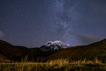 Snowcapped peak of Chimborazo volcano at night with part of the Milkyway visible  in sky above, Chimborazo National Park, Chimborazo, Ecuador. August, 2022.