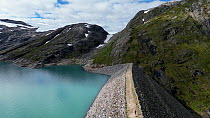 Aerial panning shot of the biggest Hydroelectric stone dam in Norway, Storglomvatnet Reservoir, Norway.