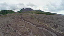 Soufriere Hills volcano and its barren landscape. As the drone accends a part of Plymouth's remains can be seen. Plymouth is Montserrat's former capital which was destroyed by the eruption of the Souf...