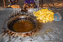Pile of fried bananas next to vat of cooking oil in village, Likoma Island, Malawi, Africa.