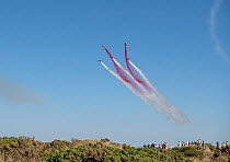 The Royal Air Force Red Arrows display team with red and white contrails,  in formation over RAF Valley Air Base, Rhosneigr, Anglesey, Wales, UK. August, 2022.
