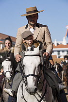 Man with son in traditional costume, parading on Lusitano horse, at the Feira da Golega, Ribatejo, Portugal.