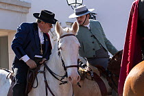 Male Riders in traditional costume talking as they ride horses, Feira da Golega, Ribatejo, Portugal.