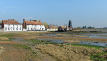 Royal Oak Inn and Langstone Old Mill viewed across saltmarshes from Langstone Quay, Chichester Harbour, Hampshire, UK. March, 2022.