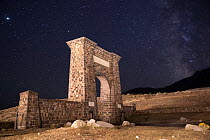 Roosevelt Arch, marking the North Entrance to  Yellowstone National Park, under a starry night sky,  Yellowstone National Park, Montana, USA. September, 2021.