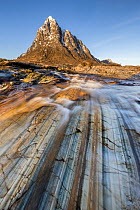 River Coupall flowing across rocks with the peak of Buachaille Etive Mor behind, Glen Coe, Highlands, Scotland, UK. March, 2022.