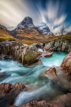 High cloud over the peaks of The Three Sisters of Glencoe with Glen Coe River in foreground, Scottish Highlands, UK. February, 2020.