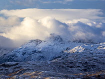 Low cloud over the snow-covered Langdale Pikes viewed from Wansfell, Ambleside, Lake District, Cumbria, UK. November, 2021.