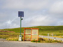 A solar powered street light next to a bus shelter near Hillswick, Shetland, Scotland, UK. July, 2022.