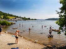 Visitors paddling in Lake Windermere during the July 2022 heatwave, Lake District, Cumbria, UK. July, 2022.