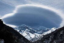 Landscape of Sierra Nevada's highest snow capped peaks with lenticular clouds over them.  Sierra Nevada National Park, Andalusia, Spain. March.