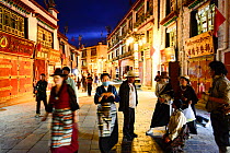 Busy street in Barkhor kora, pilgrimage circuit in old centre of Lhasa, at night. Lhasa, Tibet, China