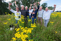 Team from ARK Nature Rewilding Europe initiative celebrating 30 years since project began at Millinger Waard, Gelderse Poort, near Nijmegen, The Netherlands. July, 2022.