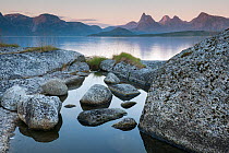 Tidepool at the edge of Tysfjorden at dusk with surrounding mountains of Stetind in background, Tysfjord, Nordland, Norway. August, 2012.