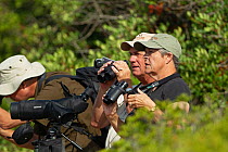 Group of birdwatchers with cameras and binoculars birdwatching, Quinta do Lago, Algarve, Portugal. October, 2018.