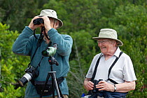 Two birdwatchers with binoculars, Quinta do Lago, Algarve, Portugal. October, 2010.