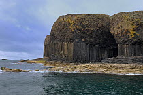 Hexagonal basalt cliffs formed by volcanic eruption with cave, Island of Staffa, Inner Hebrides, Scotland, UK, Atlantic Ocean, May 2017.