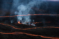 Rivers of lava running down northern slope of Mauna Loa Volcano passing around a smaller fissure, Big Island, Hawaii, USA. November, 2022.