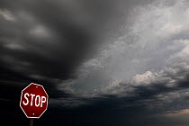 RF - Dark storm clouds over a stop sign, Badlands National Park, South Dakota, USA. June, 2022. (This image may be licensed either as rights managed or royalty free.)