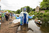 Goddess of the Wye puppet entering the river, part of the Save the Wye Campaign to raise awareness of pollution levels in the River Wye, Monmouth, Wales, UK, 9th July, 2023.