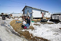 Two girls play with swing in Inupiat town of Shishmaref, Sarichef, Alaska, August 2010. Community will have be relocated due to climate change.