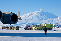 Volcanic Mt Erebus is visible from ice airstrip where cargo is being dropped, McMurdo Station, Ross Sea, Antarctica.