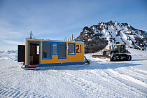 Snow plough positioning hut over ice hole for scuba diving, McMurdo Sound, Ross Sea, Antarctica.