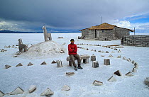 Photographer Doug Allan sits outside a Hotel made of salt, salt flats, Salar de Uyuni, Bolivia.