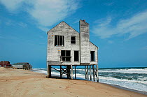 Beachside house abandoned to the surf and increasingly rapid beach erosion, Nags Head, Cape Hatteras, North Carolina, USA. October, 2004.