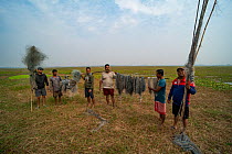 Volunteers from the Human & Environmental Alliance League (HEAL) holding up nets removed from nearby lake. The nets are used by bird poachers. Murshidabad, West Bengal. December, 2022. Bird Photograph...
