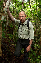 Photographer Klaus Nigge leaning against tree in rainforest whilst tracking Philippine eagles (Pithecophaga jefferyi), Mount Apo area, Mindanao, Philippines, August 2006.
