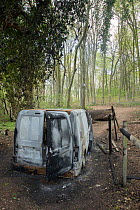 Burnt out car abandoned in woodland in a nature reserve, Hampshire, UK. May, 2021.
