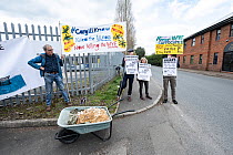 Protesters hold sign by wheel barrow of chicken farming waste at Extinction Rebellion's Save the Wye Campaign protest, Avara Cargill Chicken Processing Factory  Hereford, Herefordshire, UK, April...