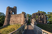 Bridge leading to ruins of Grosmont Castle tower, curtain wall and gatehouse with dry moat, Gwent, Monmouthshire, Wales, UK, October 2023.