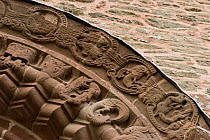 Arch over main doorway at St Mary & St David Church, with Romanesque carvings featuring a dragon eating its own tail, two fishes and and beaked head, Kilpeck, Herefordshire, England, UK, 2015. Carved...