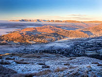 Dawn mist over valley looking towards the Langdale Pikes from Wansfell, Lake District, Cumbria, UK. December, 2022.