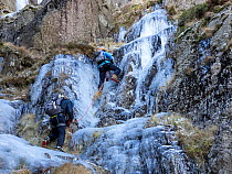 Mountaineers ice climbing on frozen waterfalls on Red Screes above Kirkstone Pass, Lake District, Cumbria, UK. December, 2022.